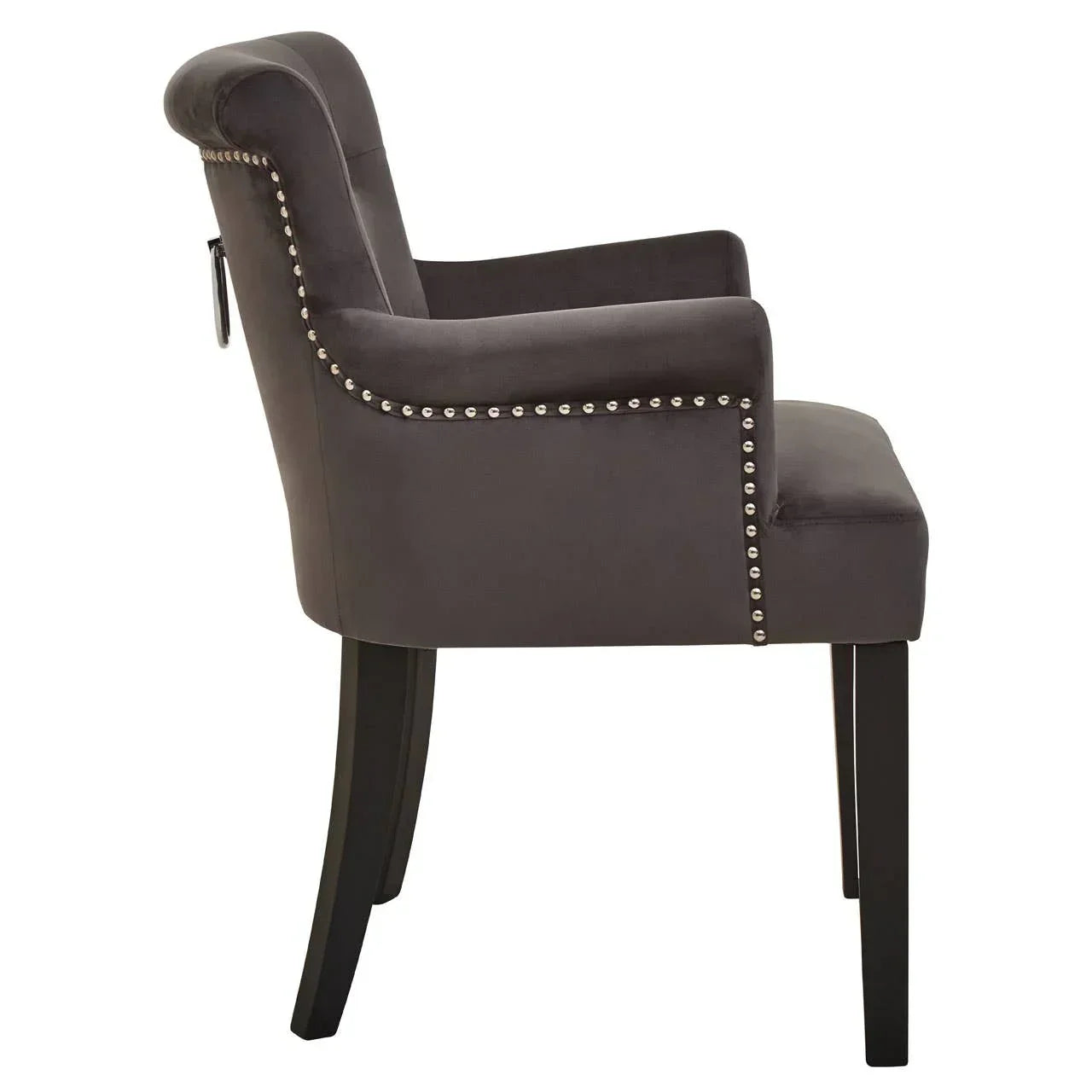 Side view of dark grey velvet dining chair with studded trim and black wooden legs