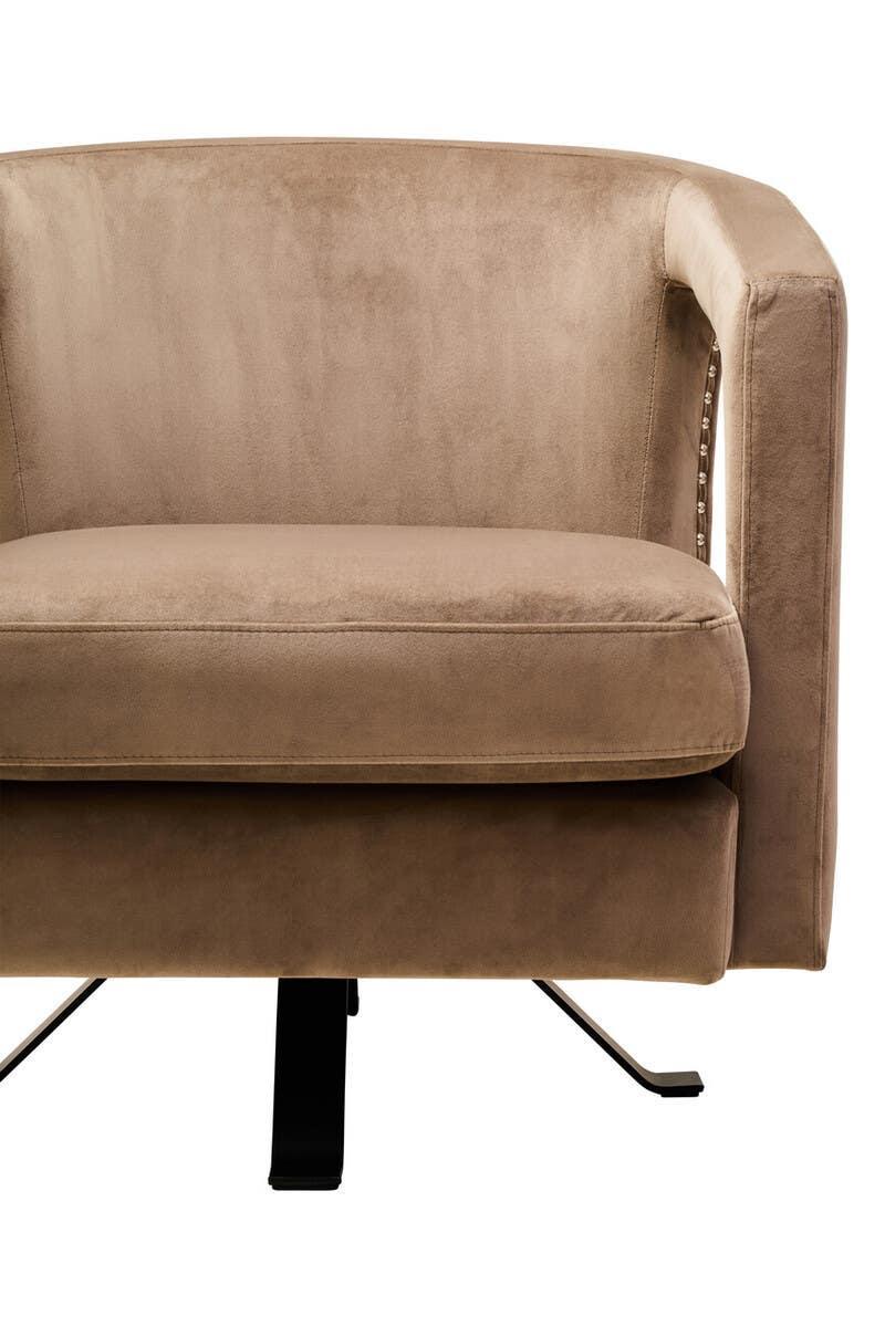 Beige velvet armchair with metal legs and stud detailing on armrest side