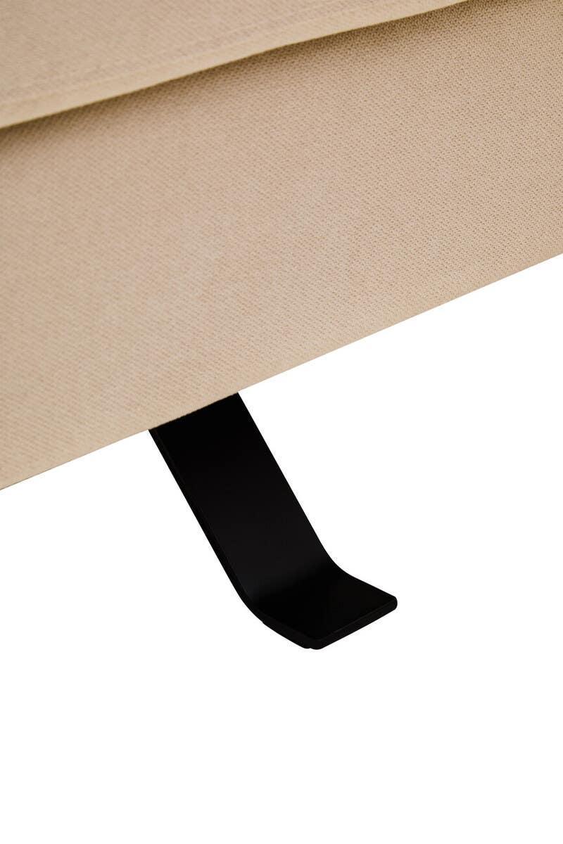 Closeup of beige fabric ottoman with black metal leg detail