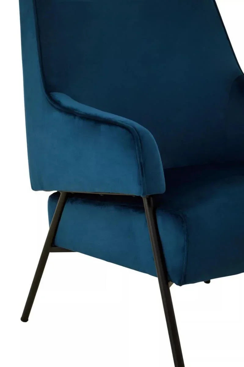 Blue velvet armchair with black metal legs, side angle close-up view