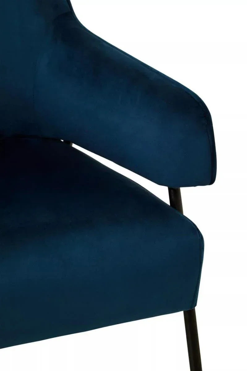 Navy blue velvet accent chair armrest and seat with black metal legs closeup