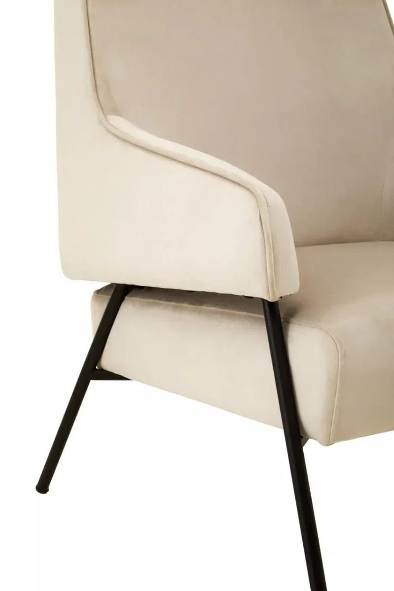 Beige upholstered dining chair with black metal legs, close-up of armrest and seat