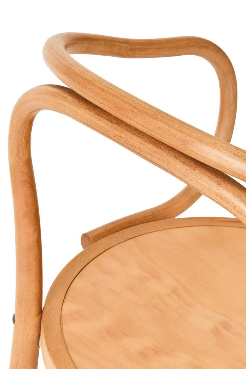 Curved wooden chair armrest and round seat in natural finish, close-up view