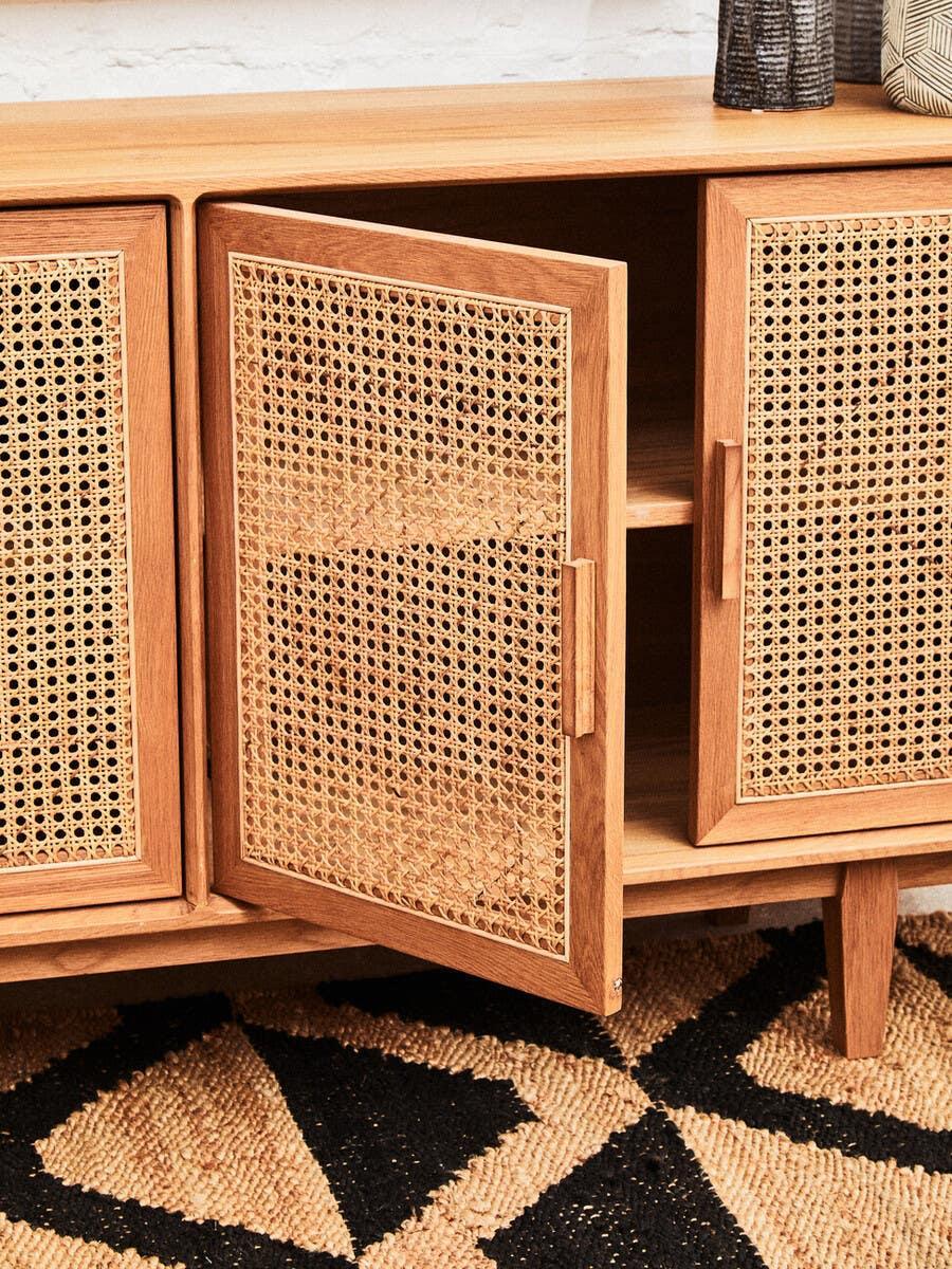 Oak sideboard with cane webbing doors, angled view showing open storage compartment