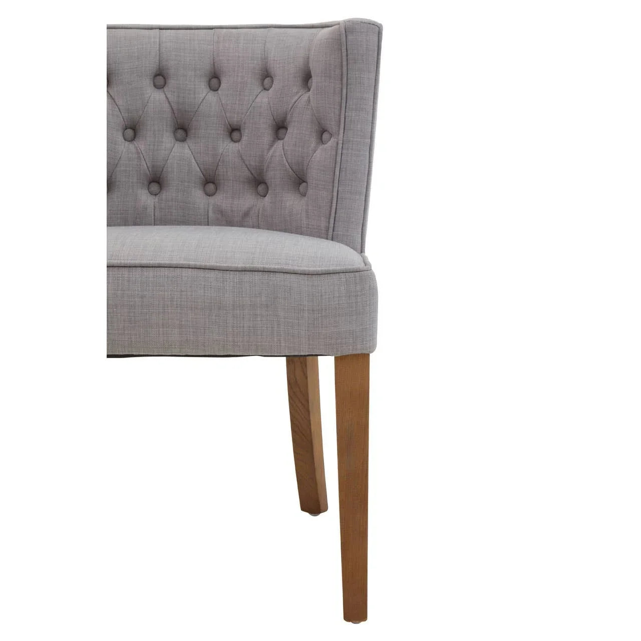 Light grey fabric dining chair with button-tufted backrest and wooden legs, side angle