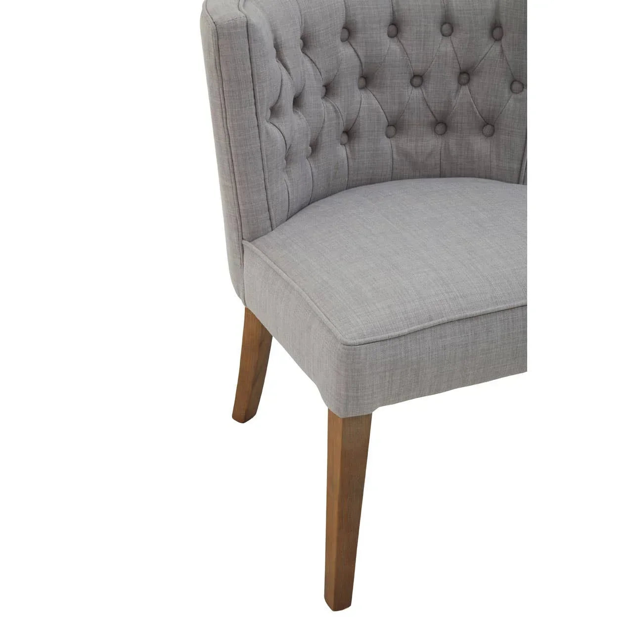 Grey upholstered dining chair with button-tufted back and wooden legs partial side view