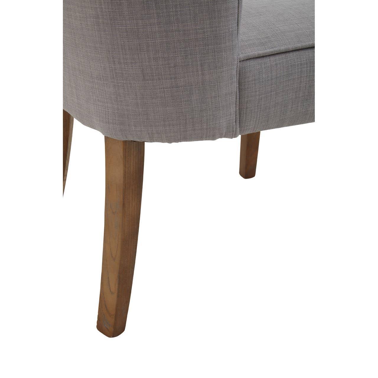 Grey upholstered dining chair with wooden legs, close-up of fabric texture and seat edge