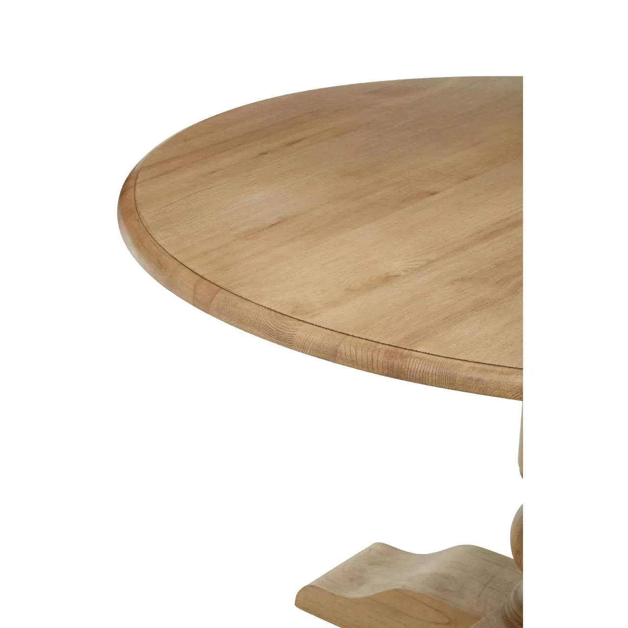 Closeup of round wooden dining table top with natural grain and carved pedestal base