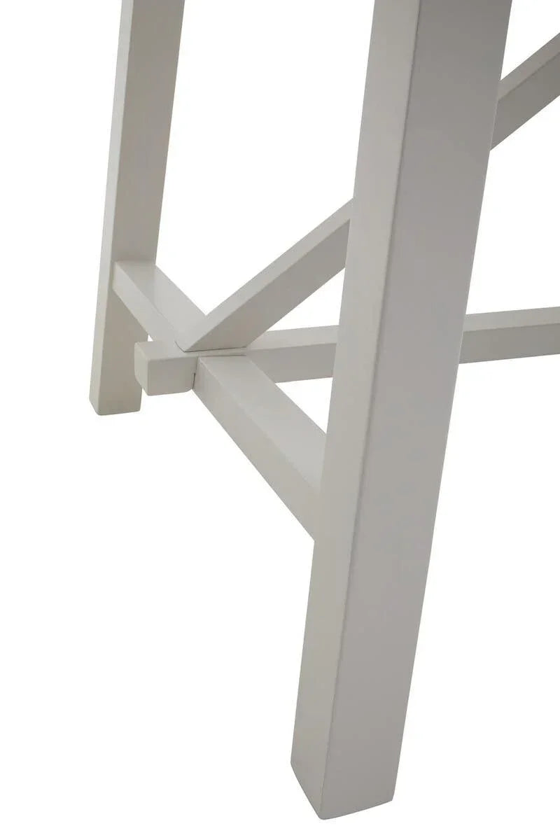 White wooden table legs with cross support detail, closeup view of furniture base