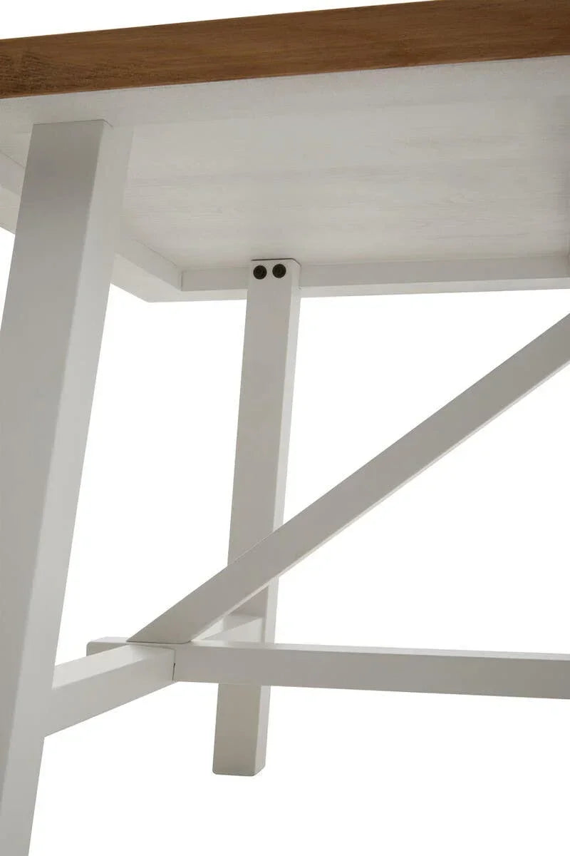 Close-up of wooden dining table base with white legs and cross frame support