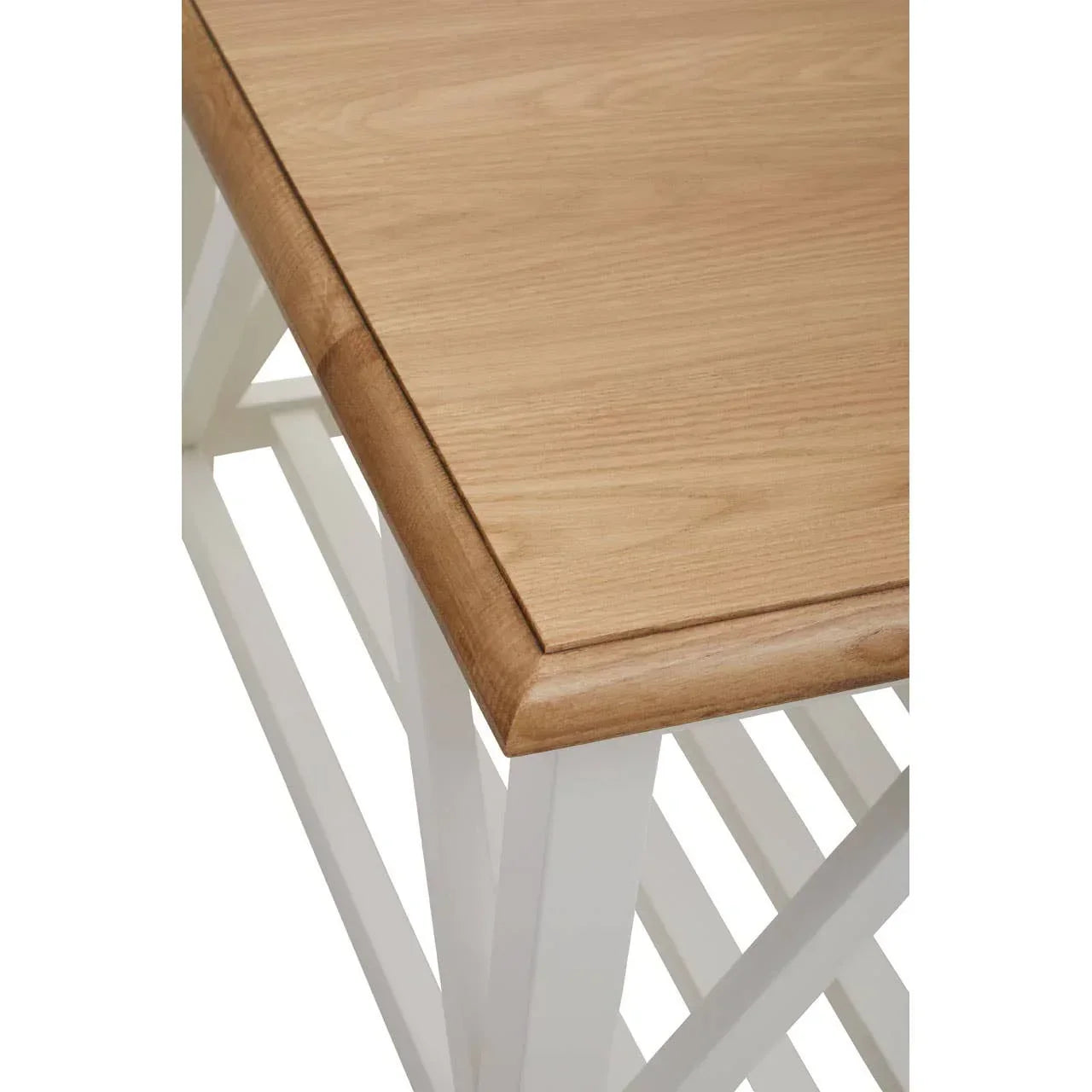 Close-up of wooden dining table top with white painted legs and slatted lower shelf