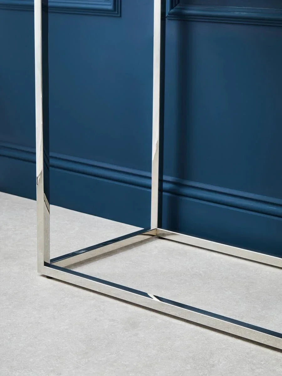 Chrome metal table legs with clean lines against blue wall and light floor
