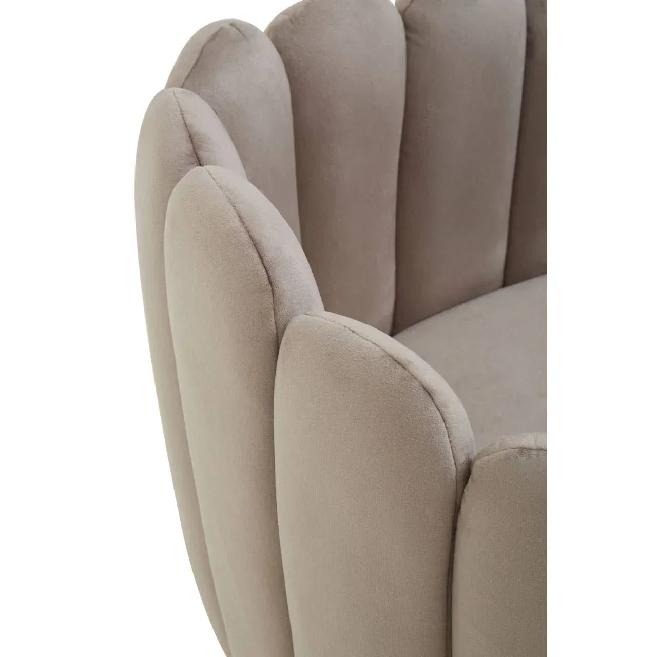 Close view of beige velvet armchair with scalloped backrest and plush upholstery