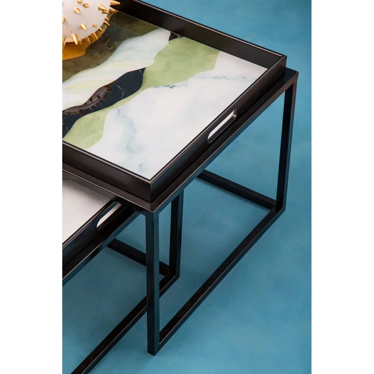 Modern nesting coffee tables with abstract marble tops and black metal frames