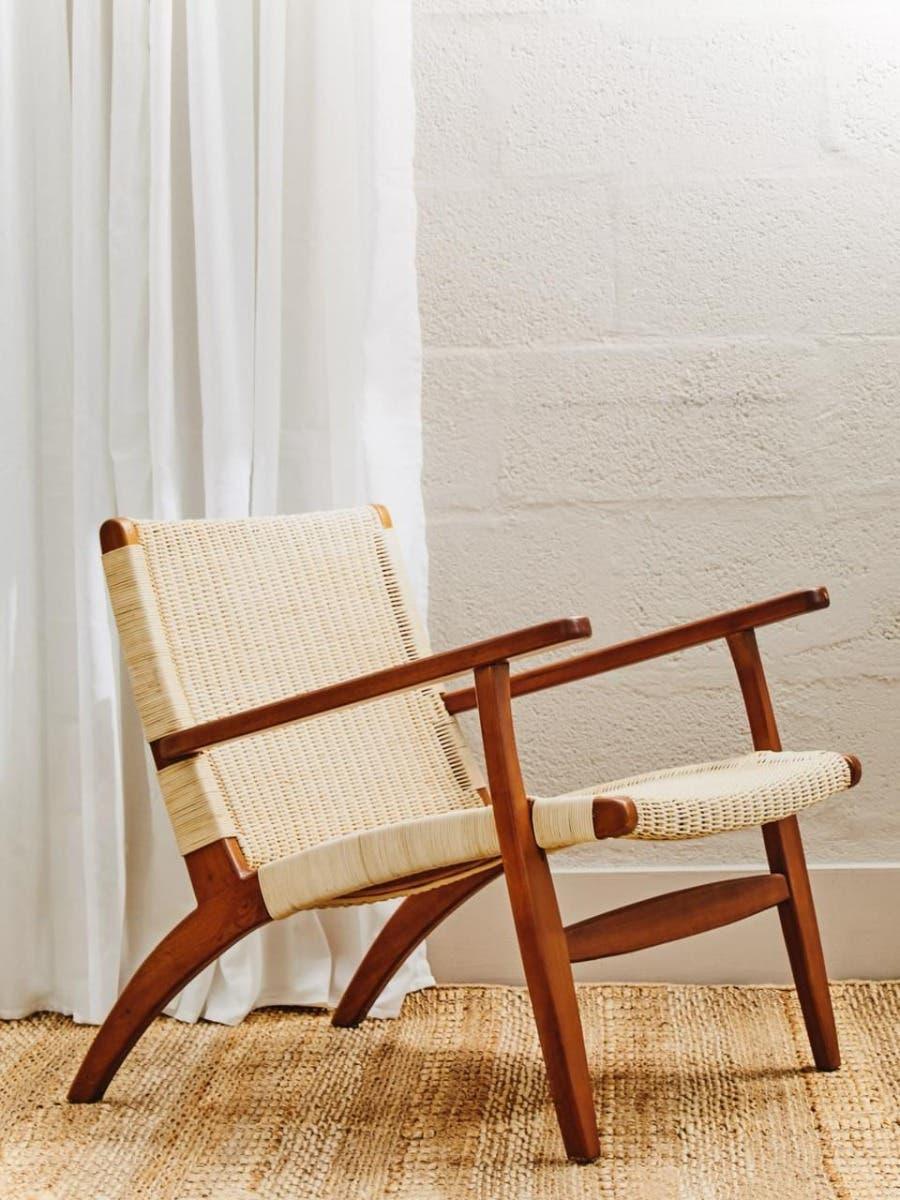 Mid-century accent chair with wooden frame and woven rattan seat and backrest on jute rug