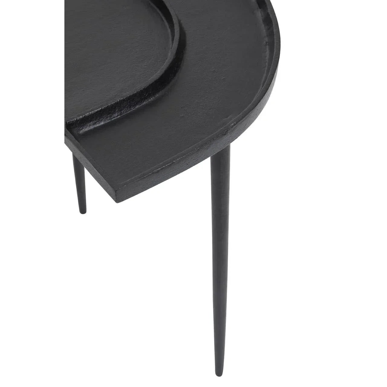 Black round side table with raised edge and slim metal legs close-up