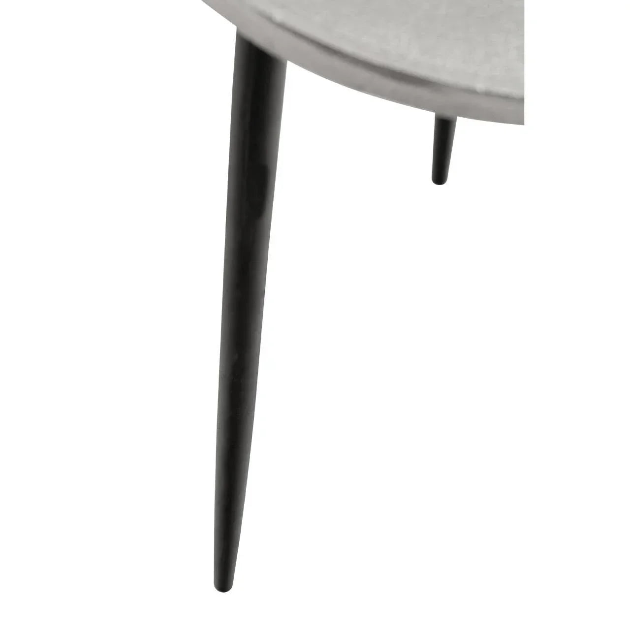 Round table with slim black metal legs and smooth grey top, close-up corner view