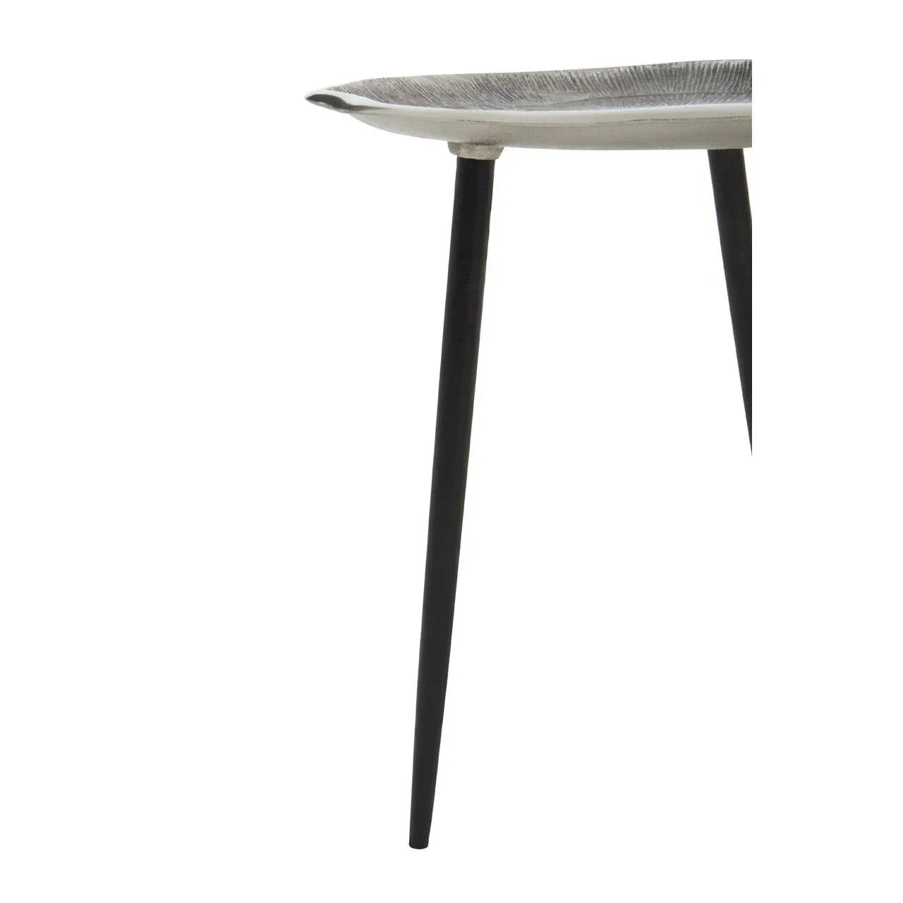 Closeup of metal side table with black tapered legs and round silver textured top