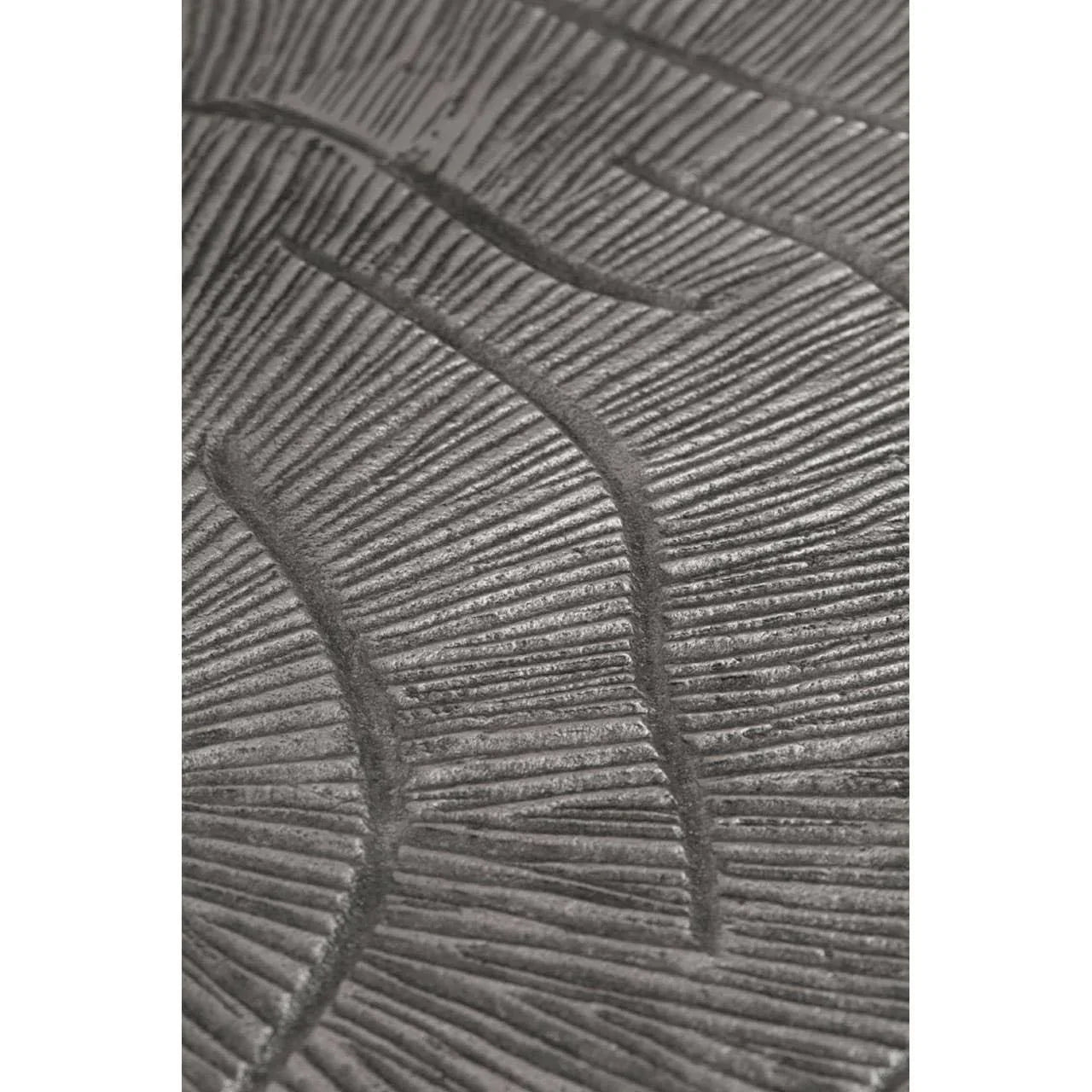 Textured metal table surface with embossed leaf pattern detail
