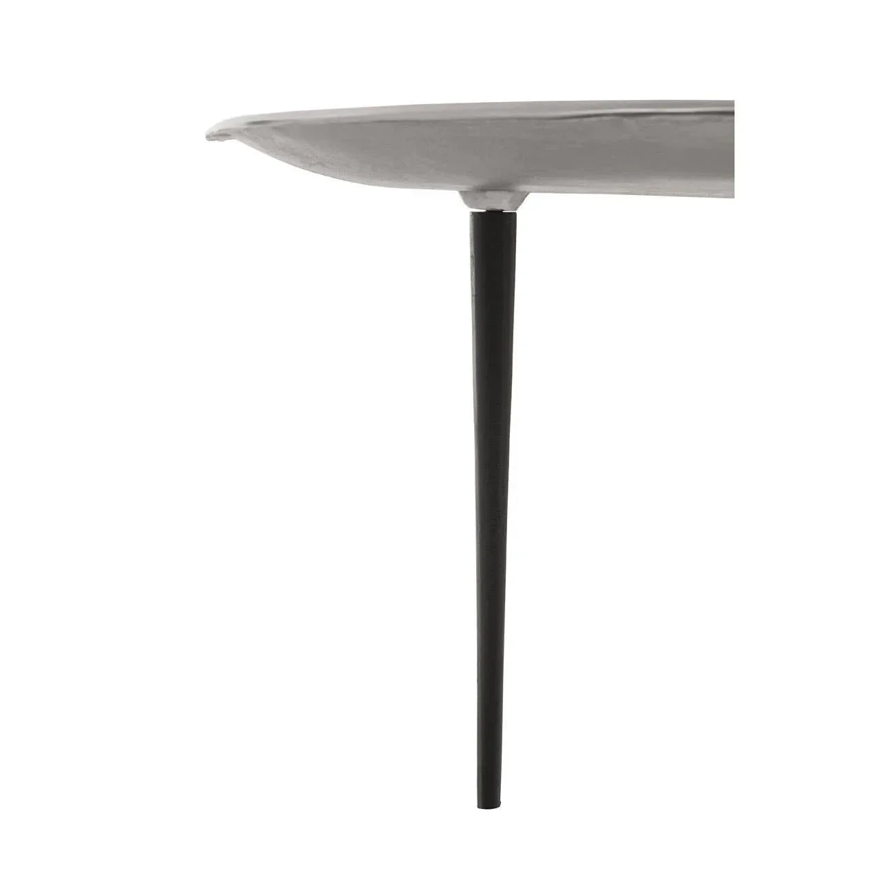 Closeup of round side table with white top and slim black metal leg