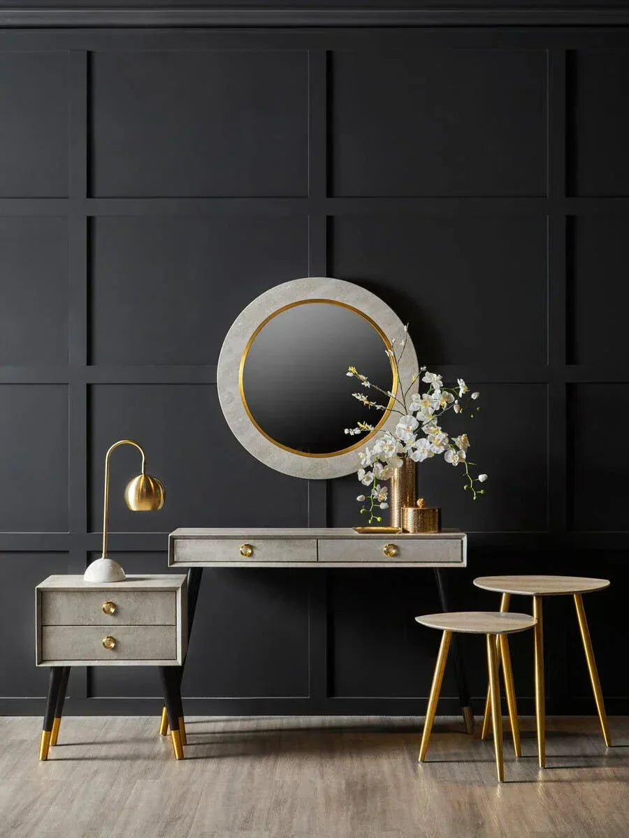 Modern console table set with gold accents, round mirror, and lamp against dark wall