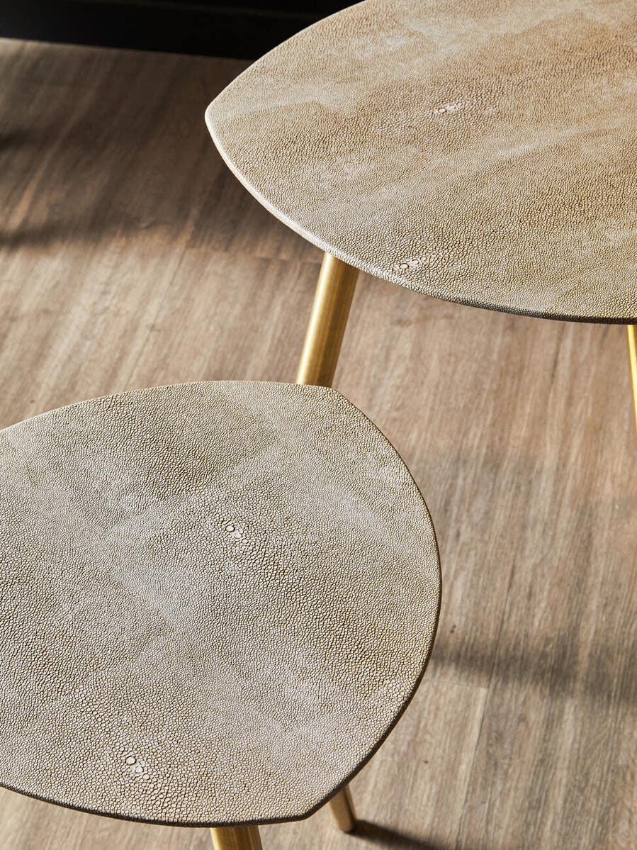 Set of two textured nesting tables with gold legs on oak wood floor