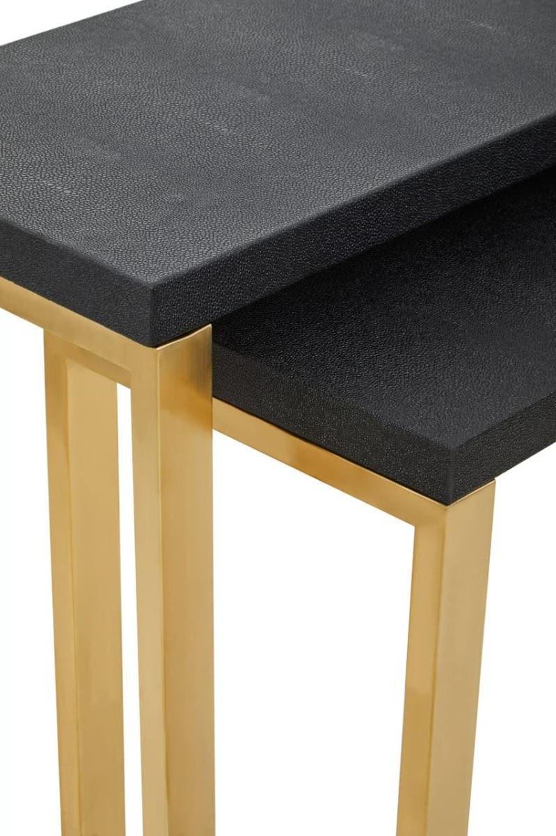 Black nesting table set with gold metal legs, close-up corner view
