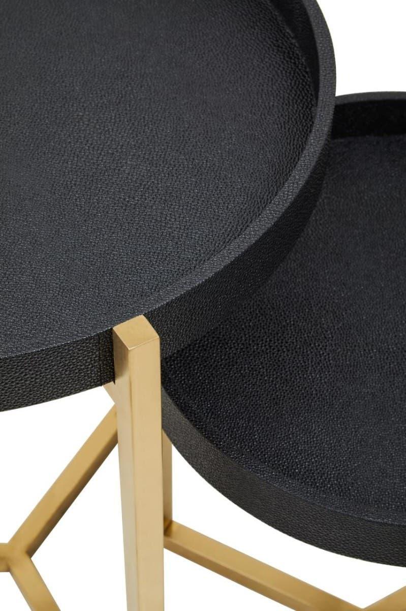 Black textured tray tables with gold metal legs, close-up of round tabletop detail