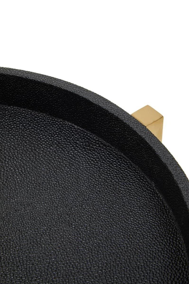 Textured black tray with raised rim and gold metal foot, close-up view