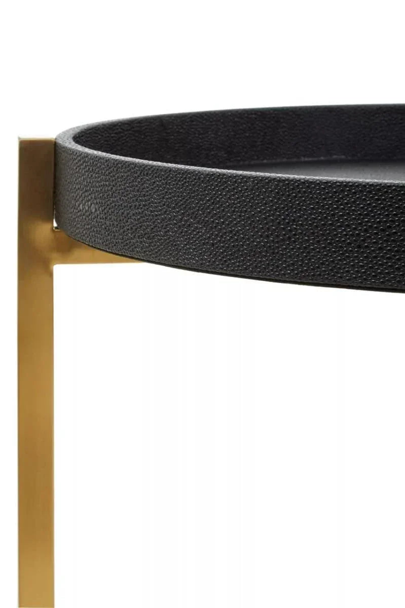 Black round side table with textured surface and gold metal frame, close detail view