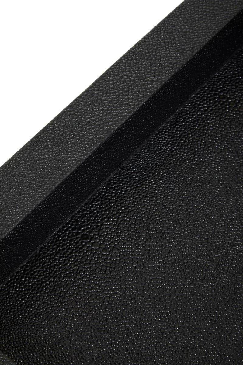 Close-up of black textured serving tray corner, showing raised edge and matte finish