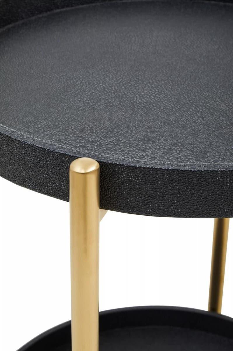 Round black side table with textured top and gold metal legs, close view of surface