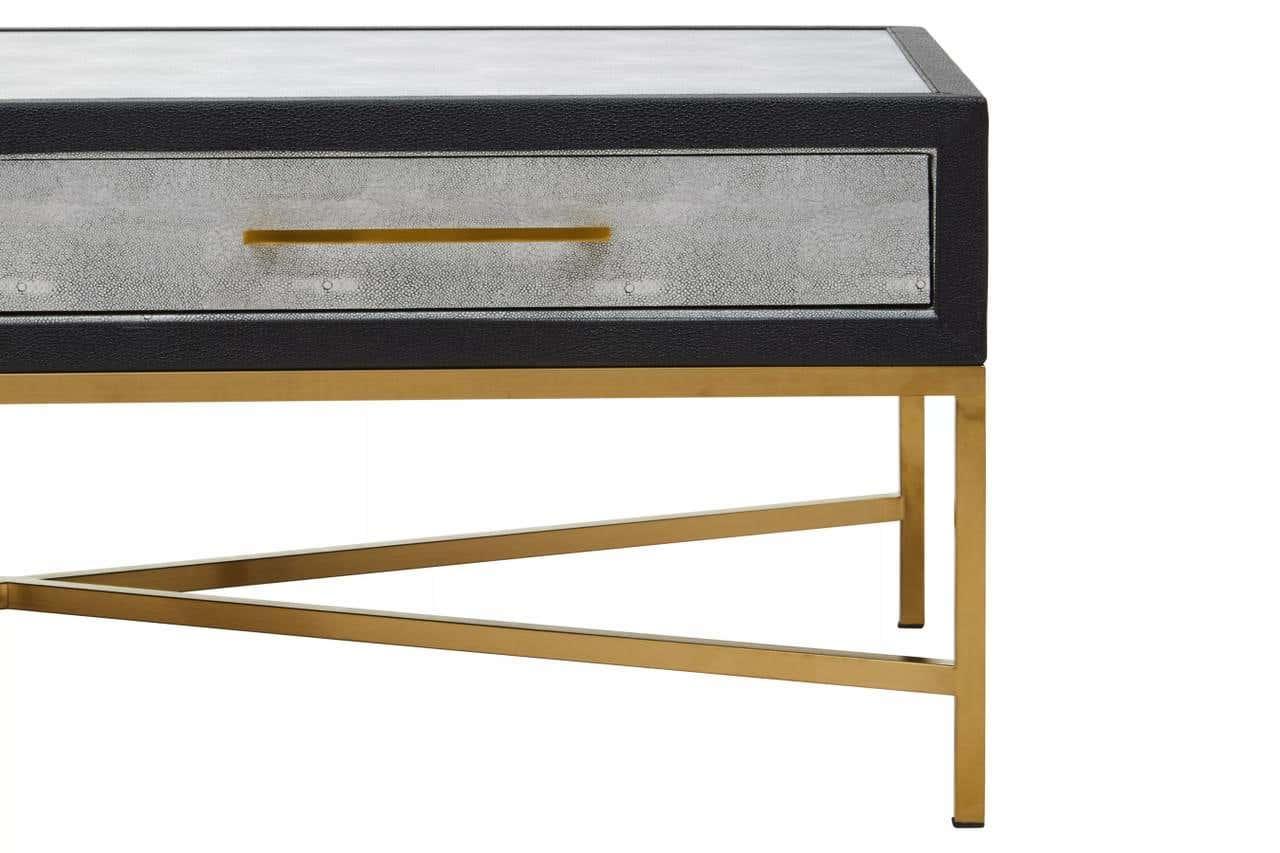 Modern side table with gold metal legs and textured drawer front