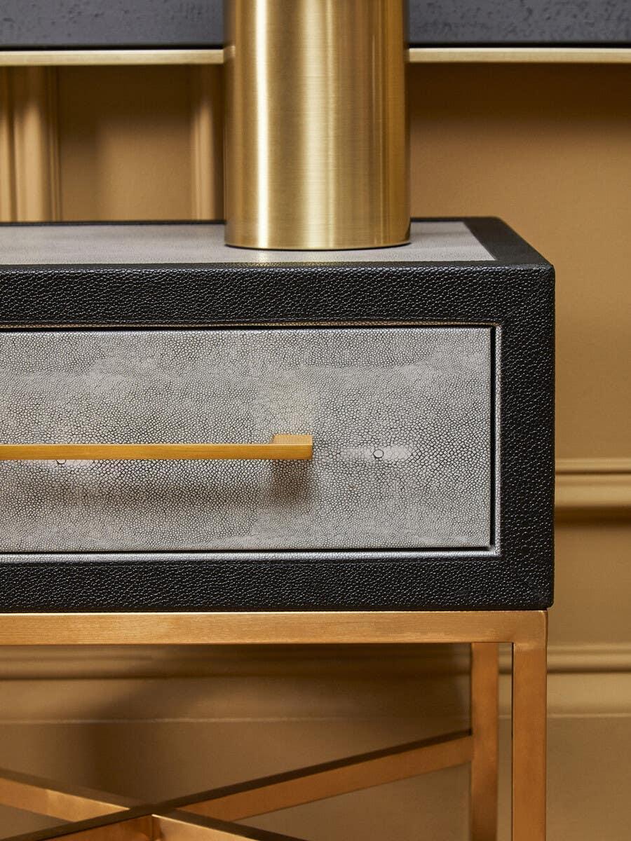 Modern console table with textured drawer, gold handle, and gold metal base