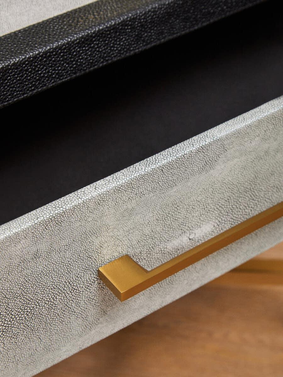 Textured drawer front with gold metal handle on modern furniture piece