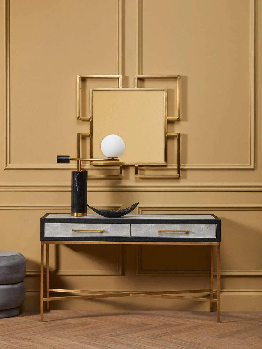 Gold and black console table with two drawers, decorative lamp and mirror, modern interior