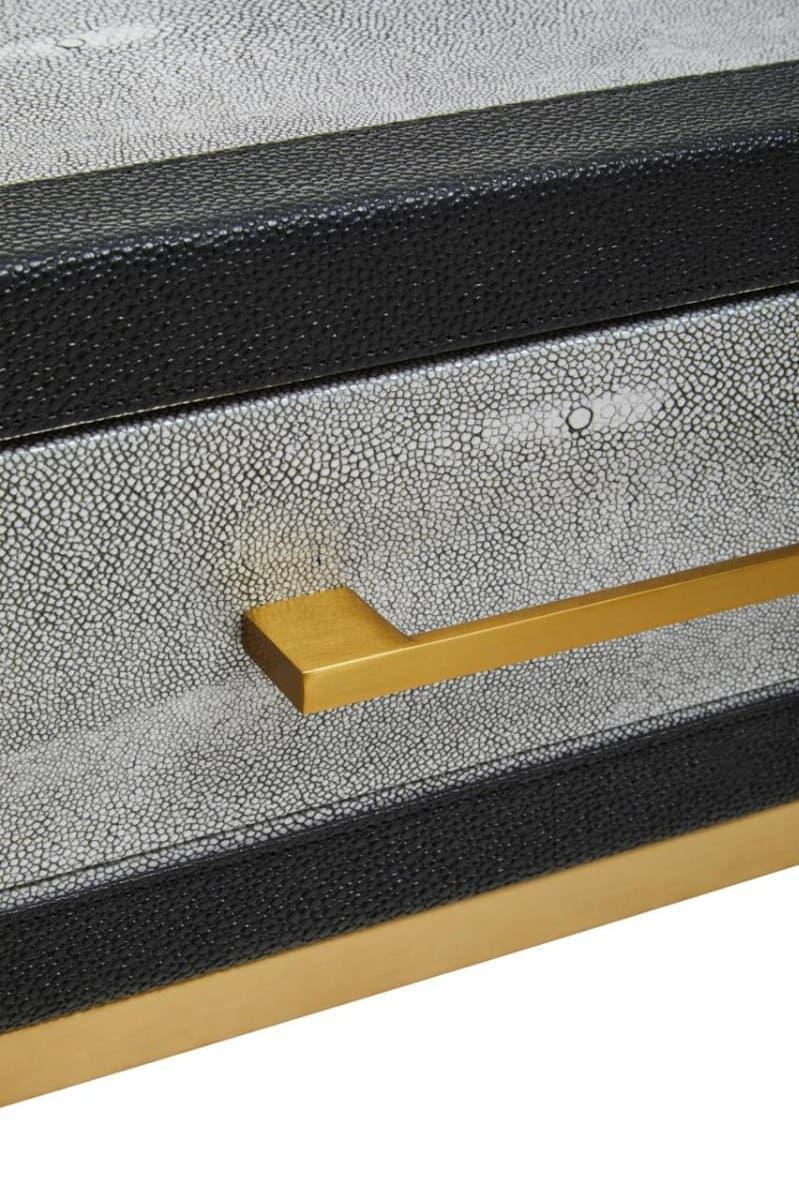 Close view of textured drawer front with gold handle and black trim