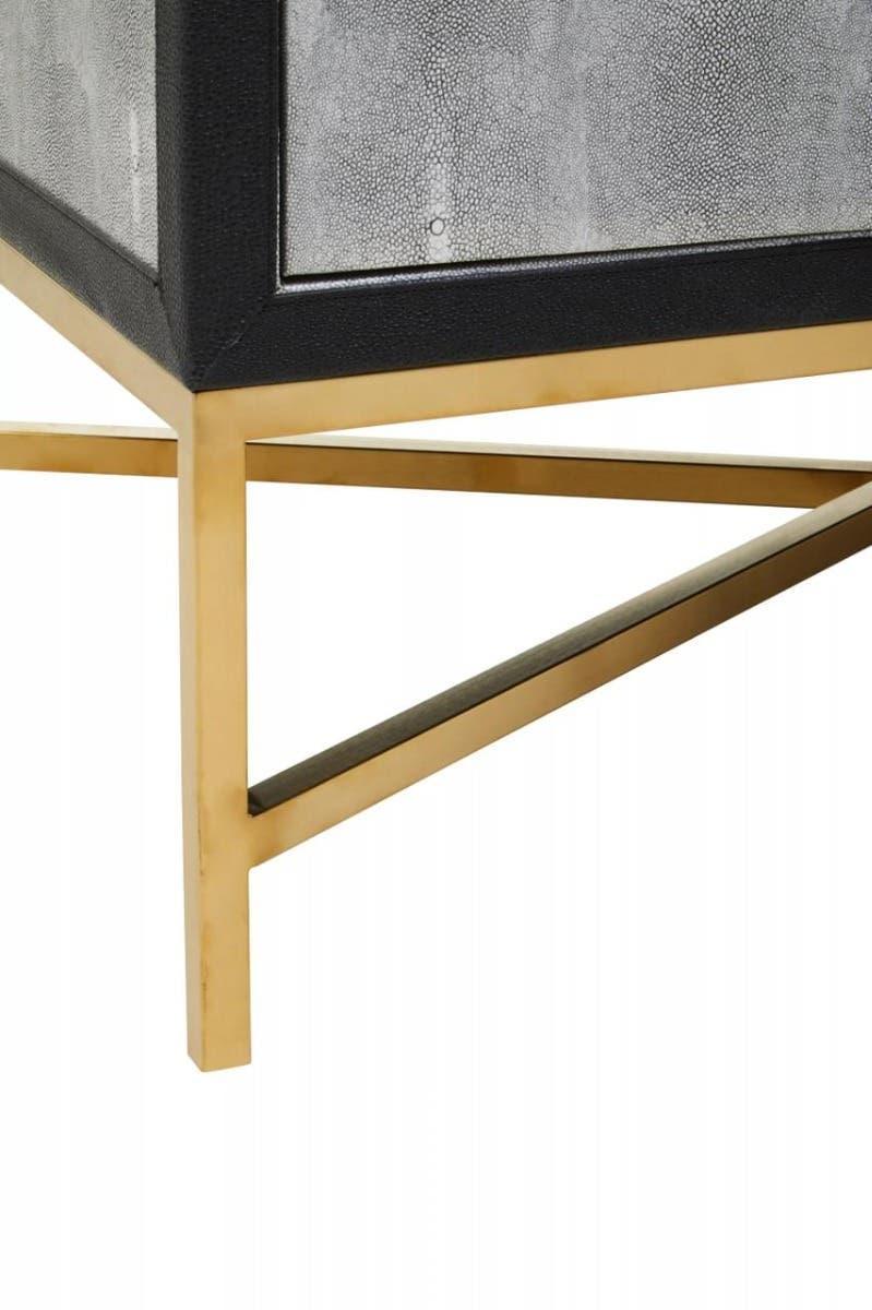 gold metal table leg with black edge and textured grey panel detail