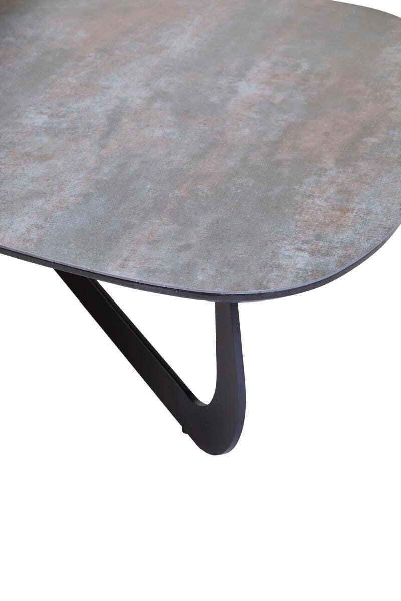 Closeup of modern dining table with grey stone-effect top and black metal angled leg