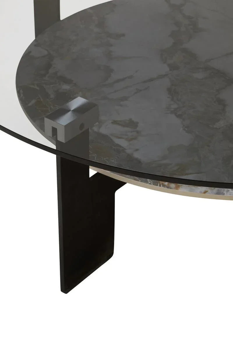 Round glass coffee table with marble shelf and black metal leg, modern detail view