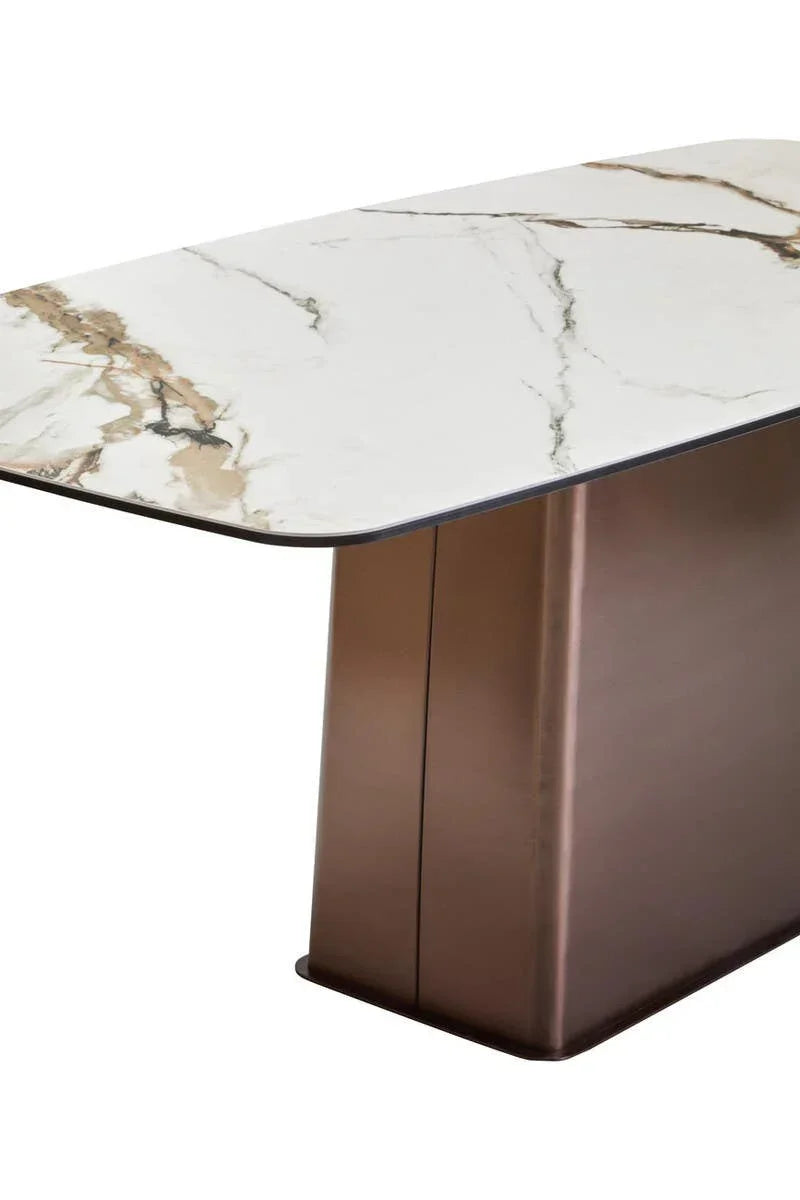 Modern dining table with white marble effect top and bronze metal pedestal base, angled view