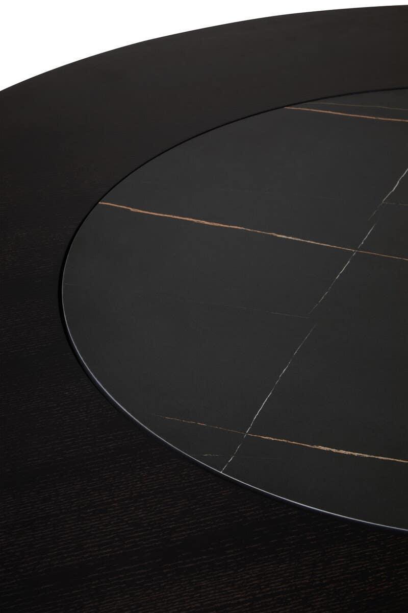 Close-up of round black dining table with marble effect central panel