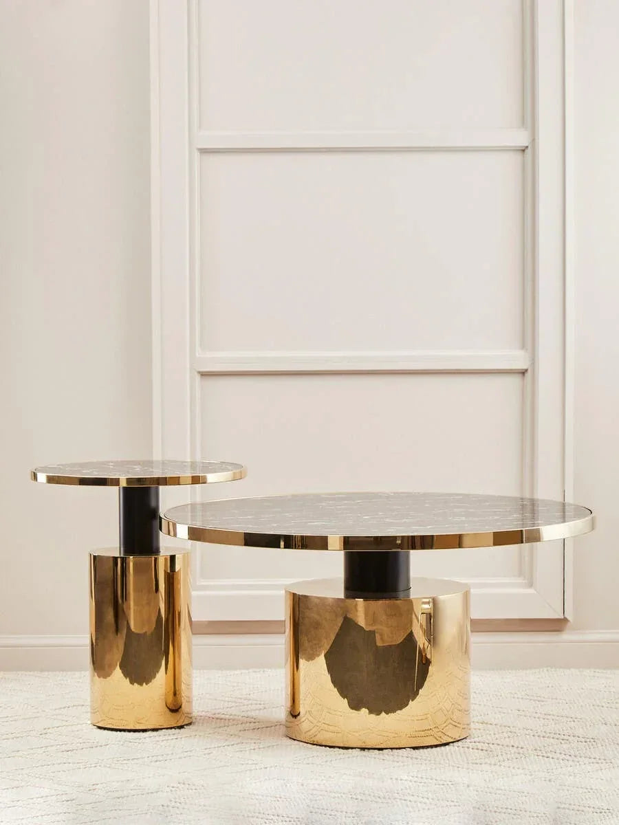 Round marble top coffee tables with gold cylindrical bases on light textured rug