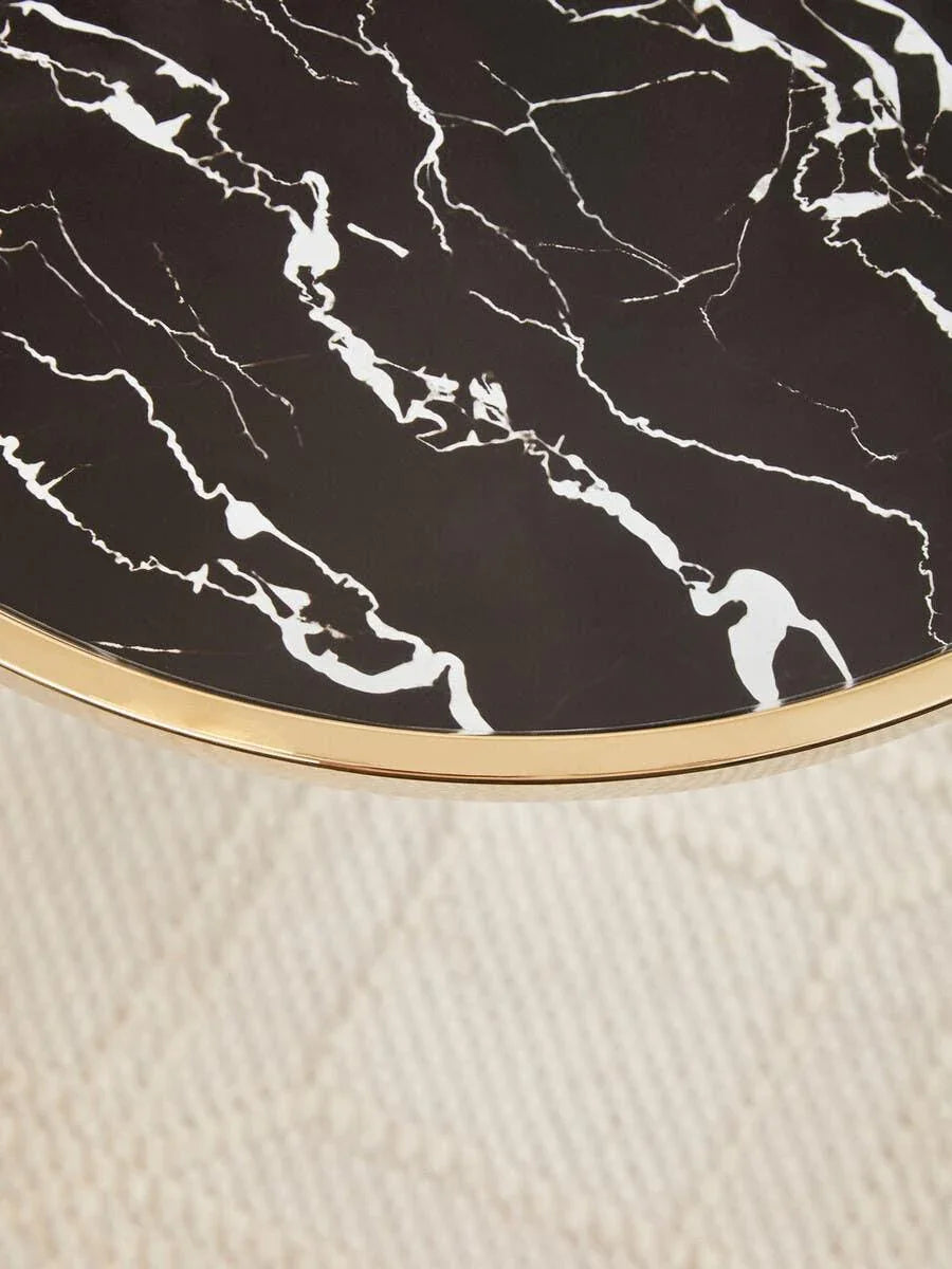 Black marble coffee table top with gold trim, close-up on modern living room carpet