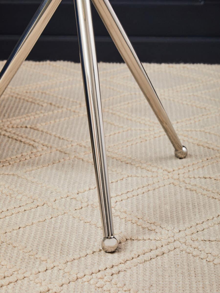 Chrome dining table legs on textured cream rug