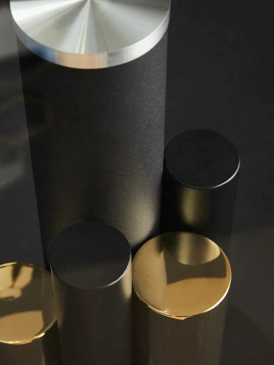 Contemporary black and gold metal table legs with brushed steel accent, close-up view