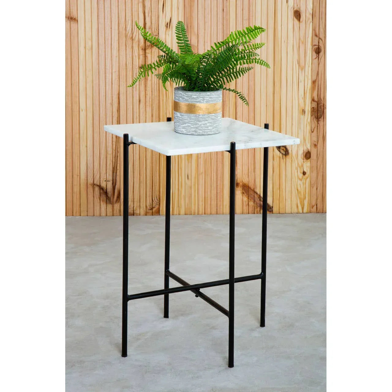 Square marble side table with black metal legs, topped with potted plant