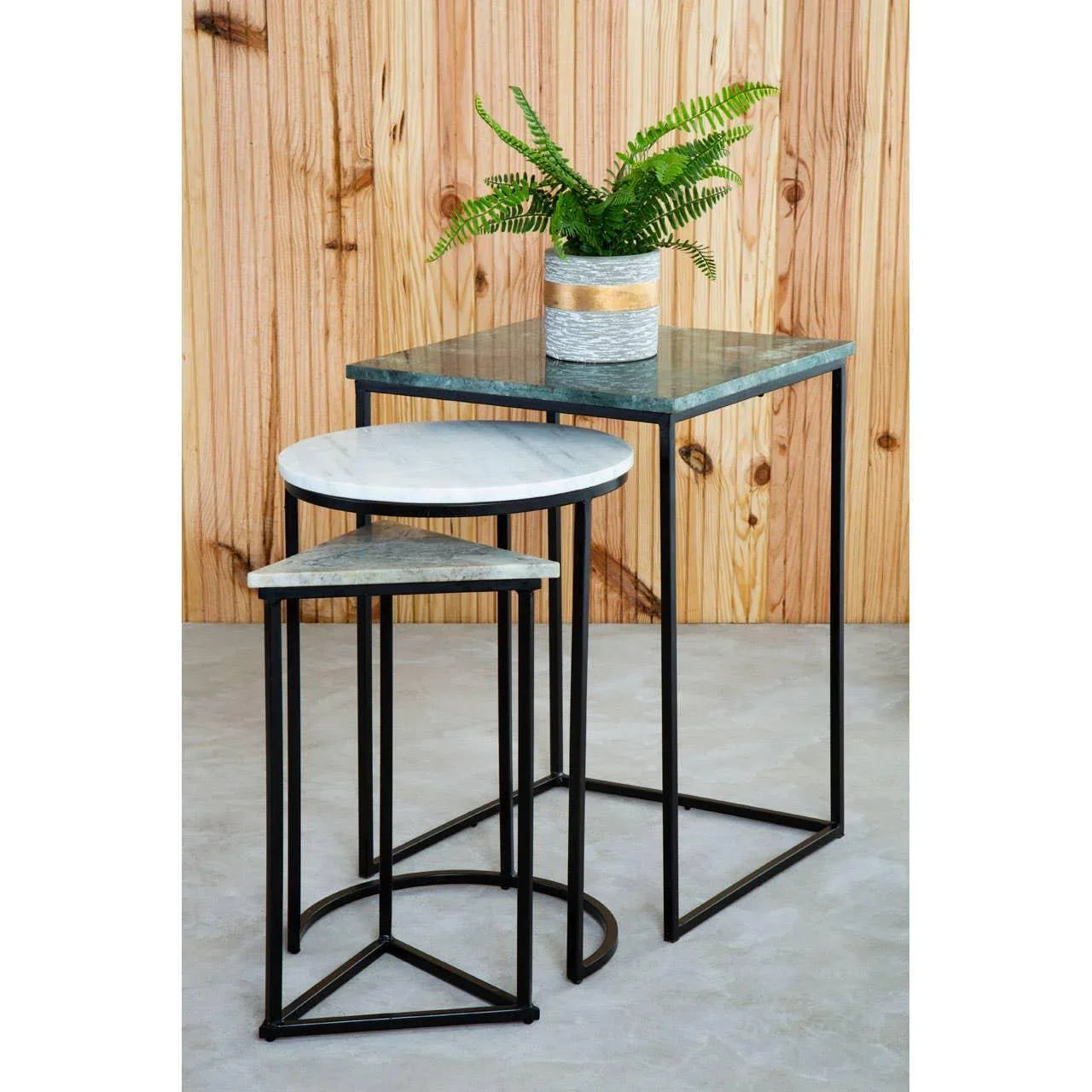 Set of marble and glass nesting tables with black metal frames, plant pot on top table