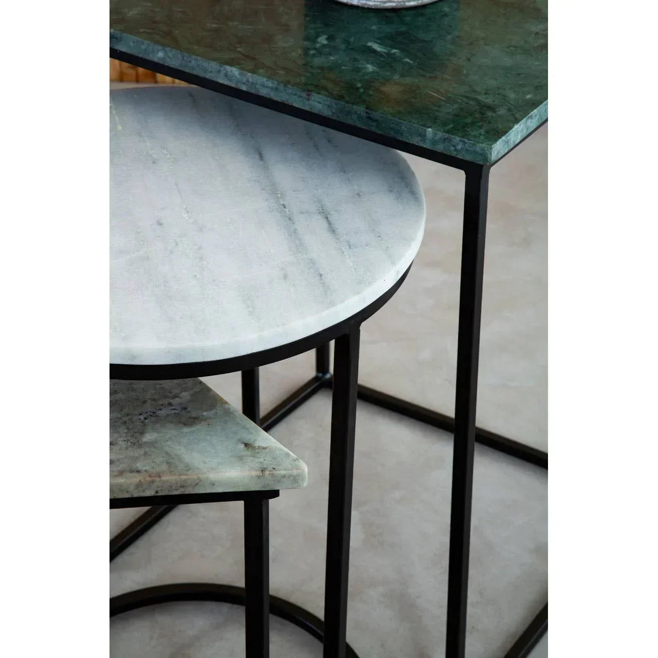 Marble nesting tables with black metal frames and mixed green and white tabletops