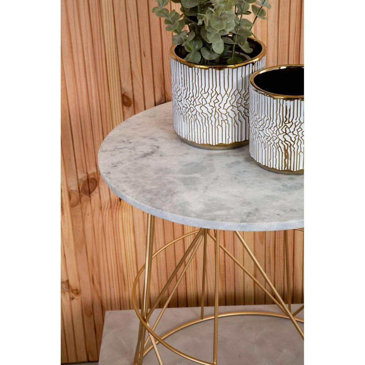 Round marble side table with gold metal legs and decorative plant pots